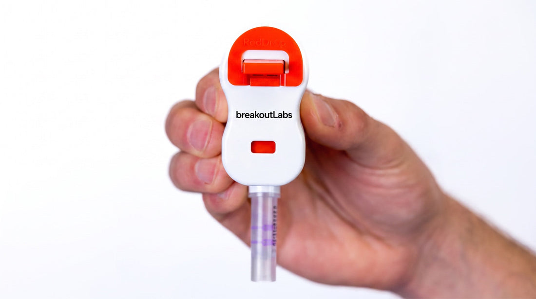 Hand holding the breakoutLabs at-home blood collection device